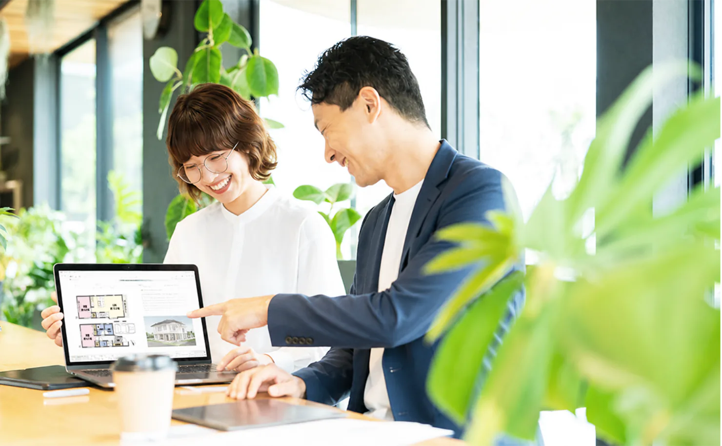 パソコンで不動産の間取り図を確認する男女